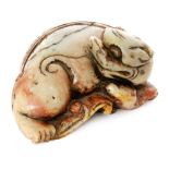 A late 18th and early 19th Century carved and shaped soapstone figure of a sleeping dragon,