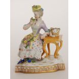 An early 20th Century Meissen figure of a seated lady sat on a stool with her arm on a table,