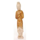 A Chinese Tang Dynasty terracotta figure of an attendant in standing pose with hands clasped,