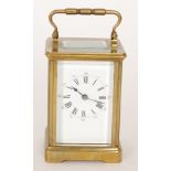 A late 19th Century French brass carriage clock with white enamelled dial striking on a gong,