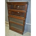 A four tier Globe Wernicke bookcase, the glazed up and over doors above a plinth base, width 87cm.
