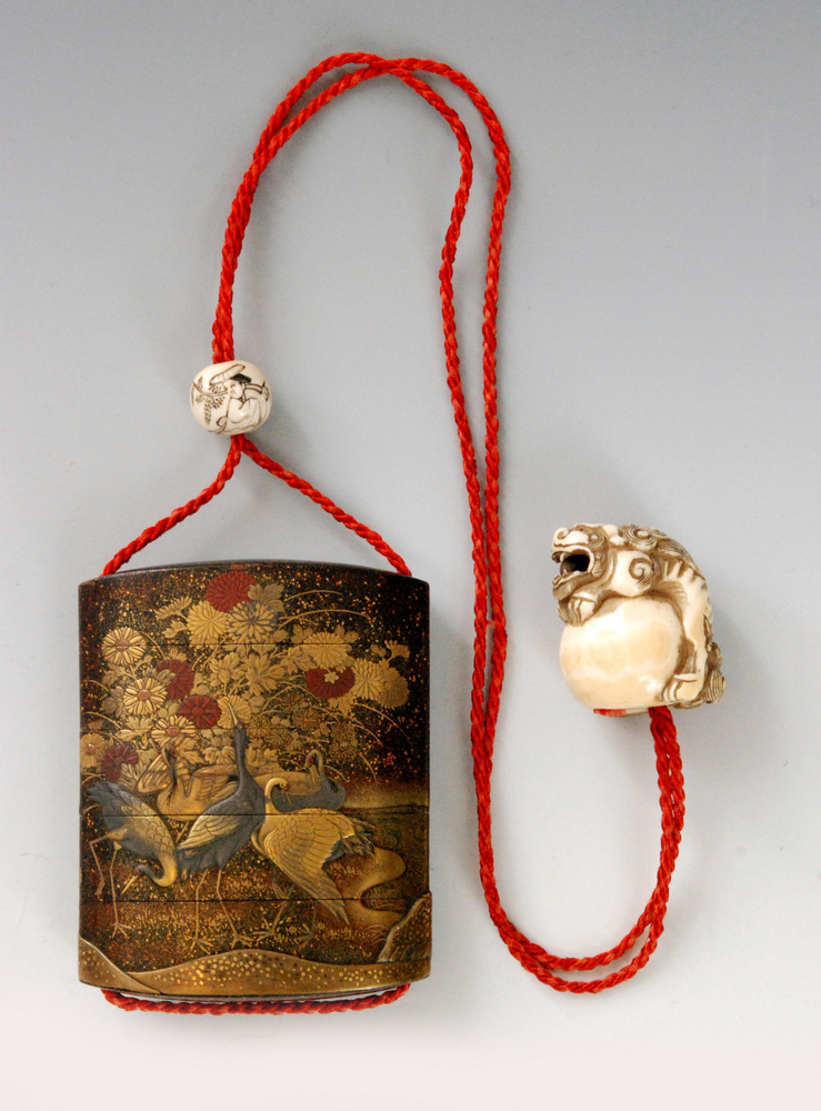 A mid 19th Century four cased inro the nashiji ground decorated with cranes to a riverbank beneath