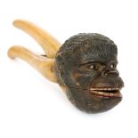 A late 19th Century beech nut cracker the head modelled as a monkey with glass set eyes and painted