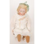 A Heubach bisque head doll with moulded and painted features wearing a green ribbon,