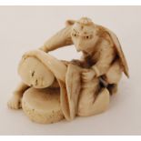 A small late 19th Century Japanese carved ivory netsuke modelled as an eagle crouching behind a