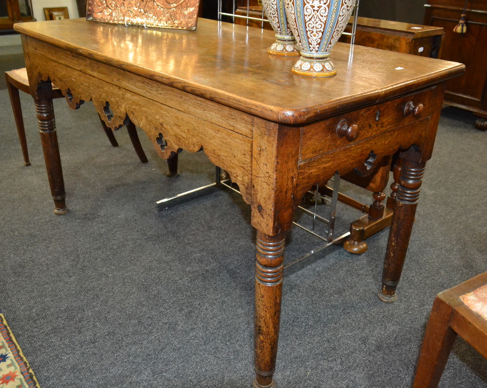 A Victorian oak side table with a single end drawer above a fret-cut apron, raised to turned legs,