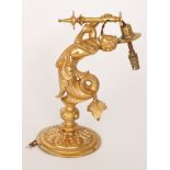 A Victorian gilt metal light fitting modelled as a Merman holding a torch to a sconce,