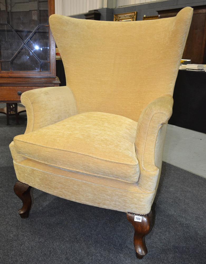 Revised estimate - An early 20th Century wingback armchair with yellow fabric upholstery,