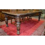 A late 19th to early 20th Century oak extending dining table with foliate carved borders,