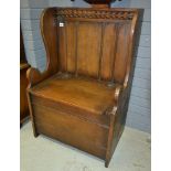 A small 17th Century style oak panelled back box settle below a carved top rail,