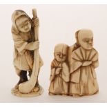 A late 19th Century carved ivory netsuke of a robed man and boy, height 4.