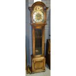 A 1930s oak longcase clock with triple weight train striking movement, with chime/silent feature,