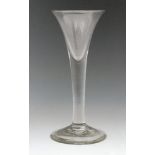 An 18th Century drinking glass circa 1740, trumpet bowl above a plain stem and a conical foot,
