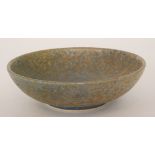 A Ruskin Pottery shallow footed bowl decorated in a mottled grey and blue glaze,