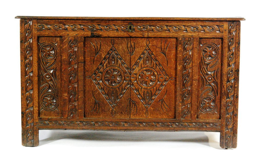 An 18th Century and later carved oak coffer with lozenge panelled front on stiles,