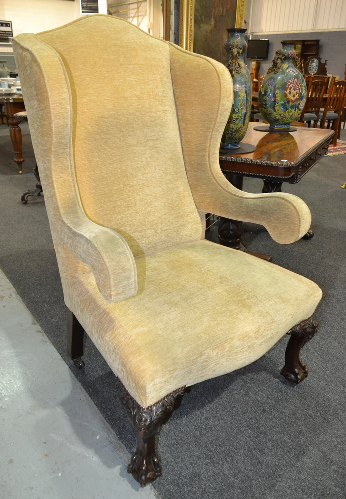 Revised estimate - An early 20th Century open sided armchair with yellow fabric upholstery,