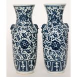 A pair of early 20th Century Chinese blue and white vases each with moulded dog head handles,