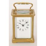 A 20th Century French brass carriage clock with white enamelled dial on bracket plinth, height 10.