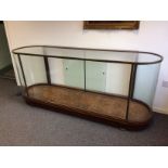 An early 20th Century brass framed and glazed shop display counter with D shaped ends,