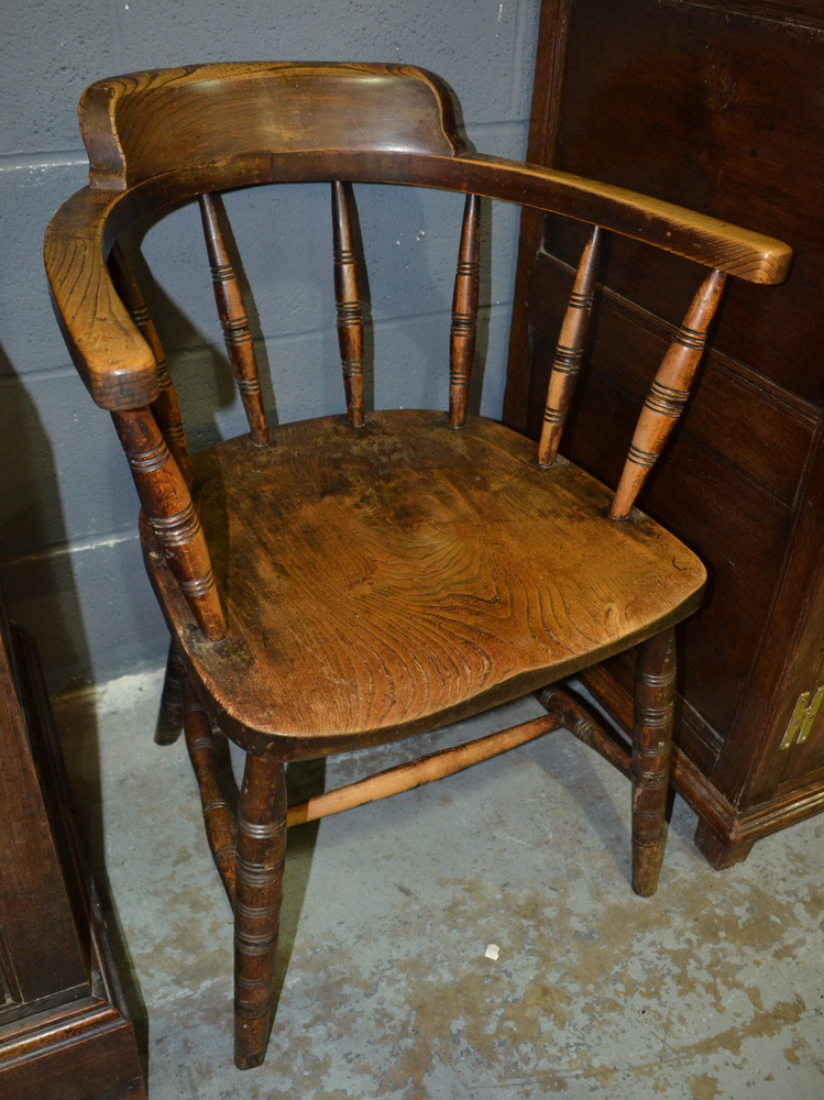 An early 20th Century spindle back elbow chair with a saddle shaped seat and stretcher frame, - Image 2 of 2