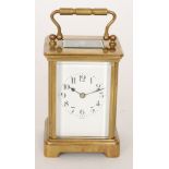 An early 20th Century French brass carriage clock with white enamelled Arabic dial striking on a