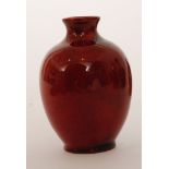 A Royal Doulton miniature flambe vase decorated in an all over tonal and mottled red glaze,