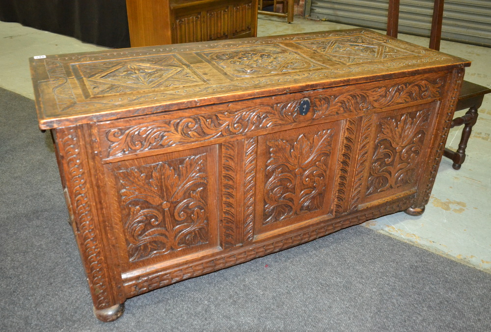 An 18th Century and later carved oak coffer, with internal candle box,