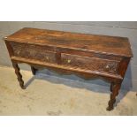 An early 19th Century oak two drawer dresser base fitted with two carved lunette front drawers,