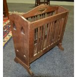 A Liberty style oak magazine rack with slatted sides and shaped ends,