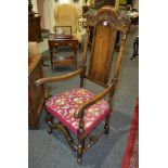 An early 20th Century oak open armchair with an acanthus scroll top rail,