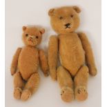 An early 20th Century English teddy bear with metal stud eyes stitched nose and jointed limbs,