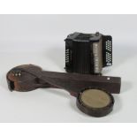 A cased Banjo (damaged); together with an Accordion.