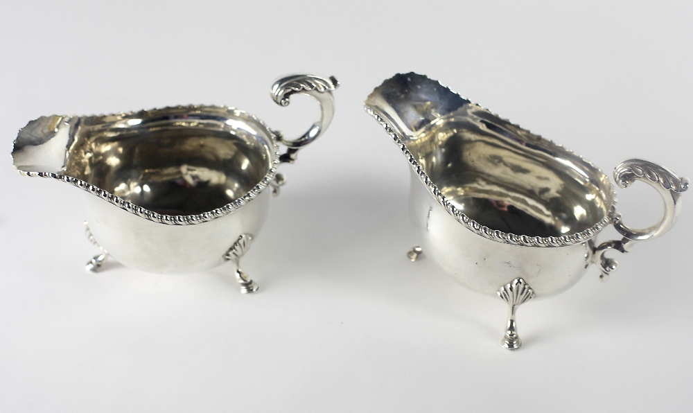 A pair of heavy English silver Sauceboats, each with gadroon borders and shell and pad feet,