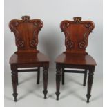 A pair of William IV Irish mahogany Hall Chairs, with shield shaped backs on carved front legs.