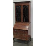 An Edwardian slope front Bureau, with fitted interior above three drawers raised on cabriole legs,