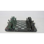 An unusual brass Chess Set, modelled as Ancient Roman Figures, on a chequered marble board.
