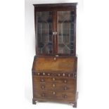 An early Georgian mahogany Bureau Bookcase, with two astragal glazed upper doors,