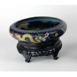A Chinese cloisonne Dragon Bowl, of low proportions, with Oriental wooded stand.