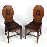 A pair of Irish 19th Century oak shield back Hall Chairs, with hollowed out seat,