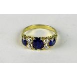 An attractive 18ct gold Ring, set with three sapphires and four diamonds, (.