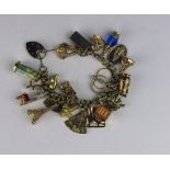 A 22 piece 9ct gold Charm Bracelet, with various charms including Eiffel Tower, Our Lady, Rings,