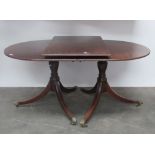A Georgian style mahogany two pod Dining Table, with reeded edges, and spare leaf,