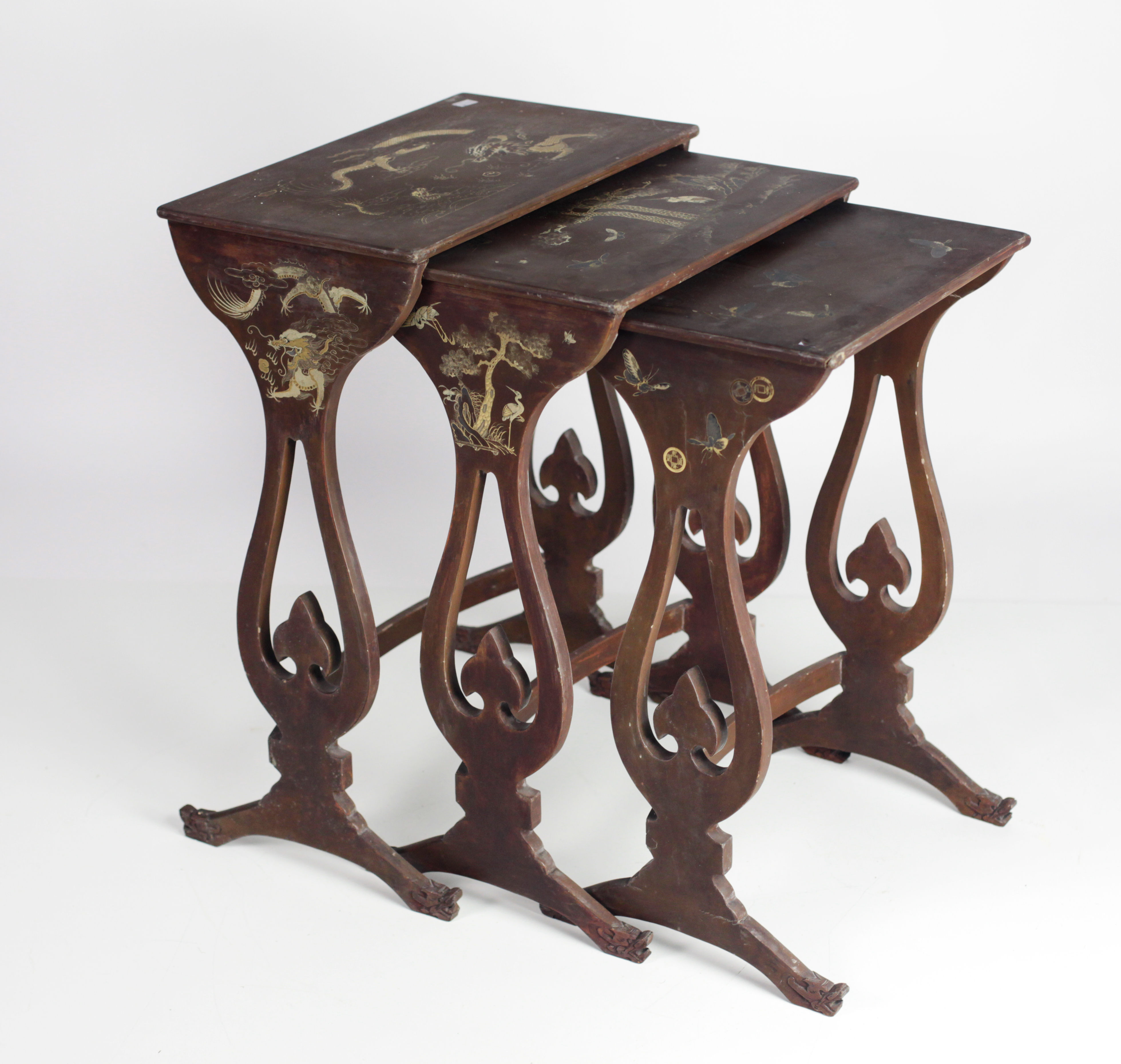 An Oriental lacquered Nest of three Tables, with gilt painted decoration and with dragon head feet.