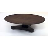 An early 19th Century mahogany "Lazy Susan" on triform base, with pillar support and brass castors,