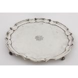 An early 20th Century large silver Salver, with piecrust edge on scroll feet,