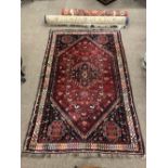 A large attractive crimson ground Rug, with angled corner decoration,