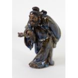 A good quality late 19th Century large glazed porcelain Figure of a Sage, holding a bat on a fan,