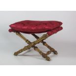 A 19th Century giltwood folding Stool, with loose cushion and material support,