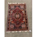 An attractive red ground Eastern Rug, with large centre medallion and four corner decorations,