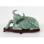 A small carved jade? Figure of a Buffalo Resting, on a wooden stand, 11.5cms x 20.